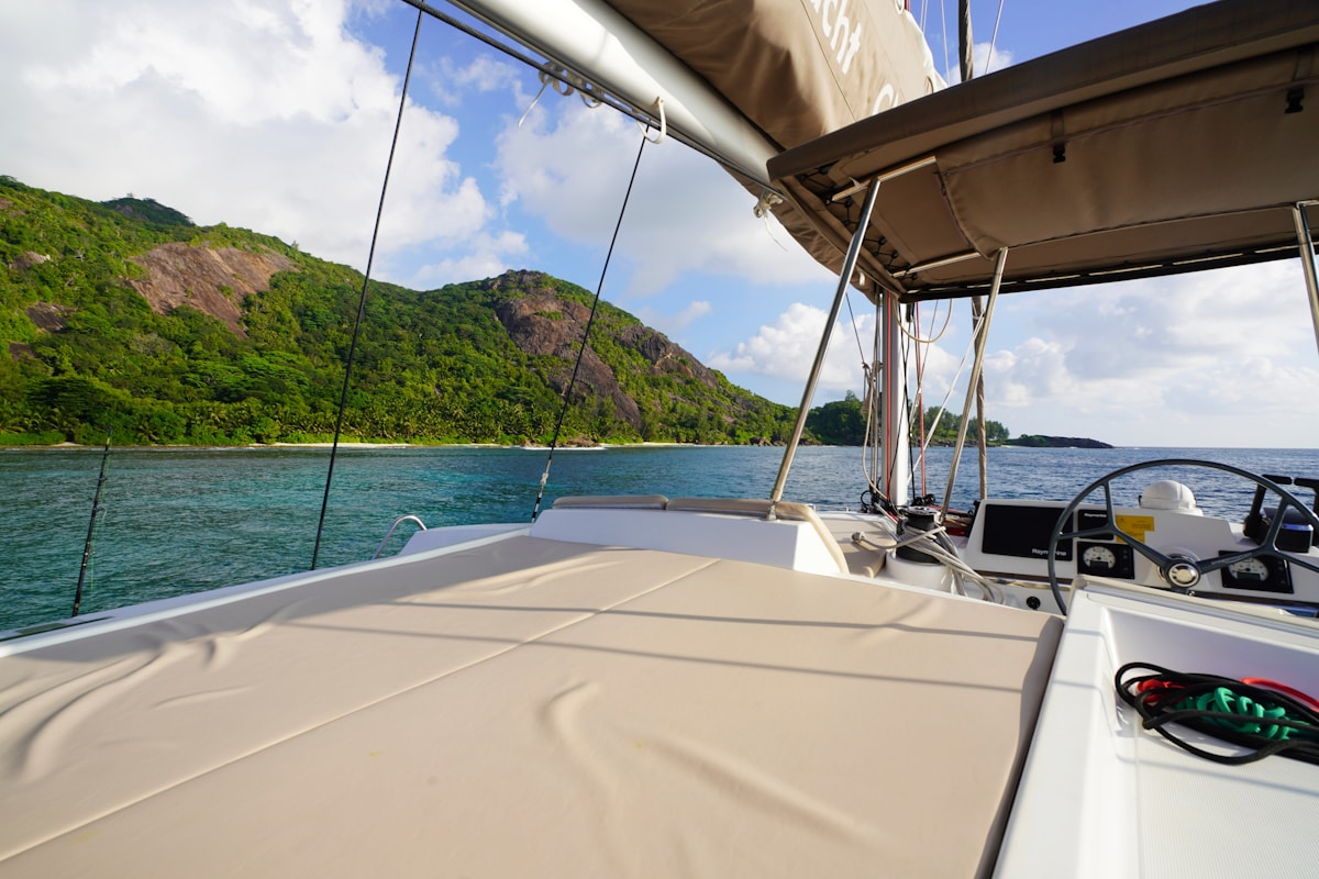 View from the deck of a private luxury catamaran sailing past a tropical island