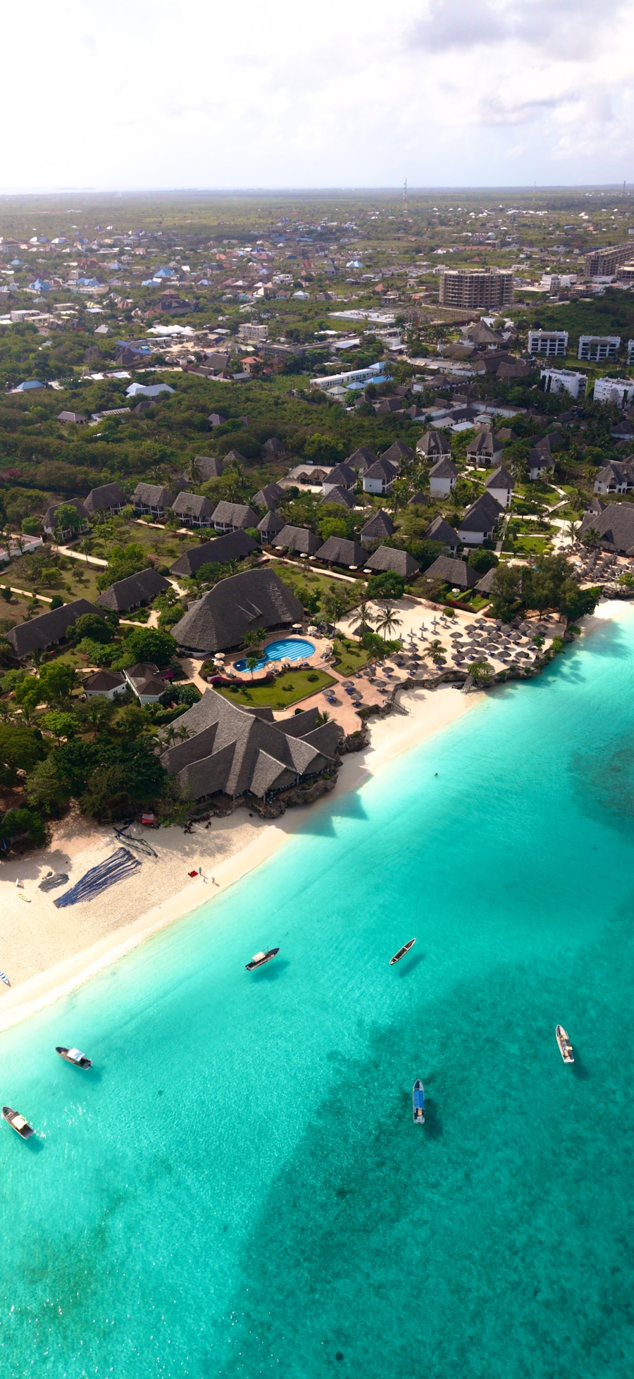 A luxury thatched-roof resort on a white sand beach in Zanzibar